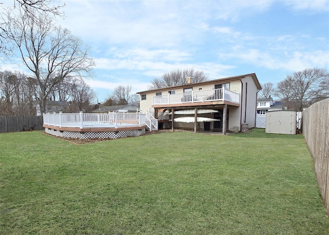 rear view of property with a storage unit, a wooden deck, a fenced backyard, and an outdoor structure