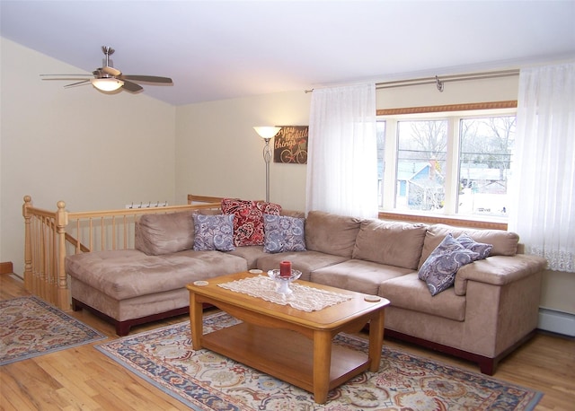 living area featuring wood finished floors, a ceiling fan, and a baseboard radiator