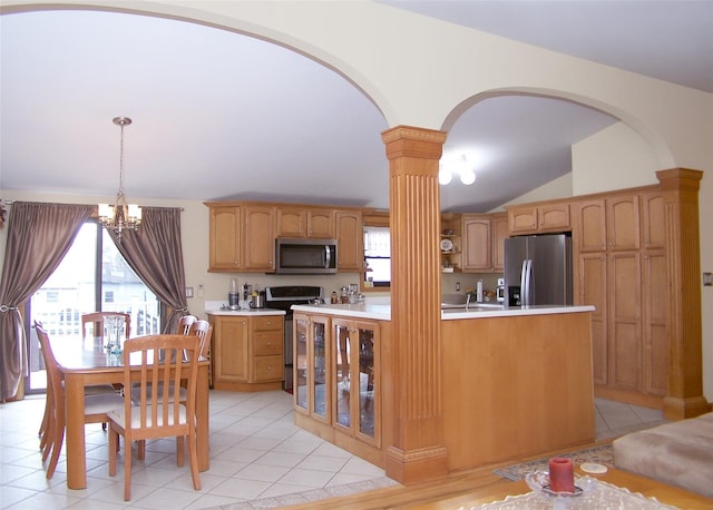 kitchen with arched walkways, a healthy amount of sunlight, stainless steel appliances, and ornate columns