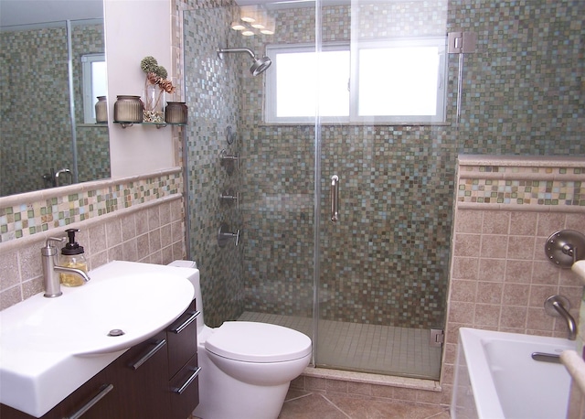 full bath featuring toilet, a stall shower, tile walls, and vanity