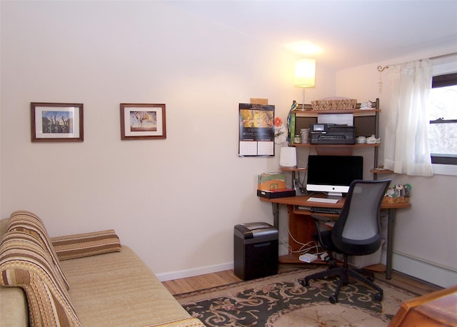 home office featuring wood finished floors, baseboards, and a baseboard radiator