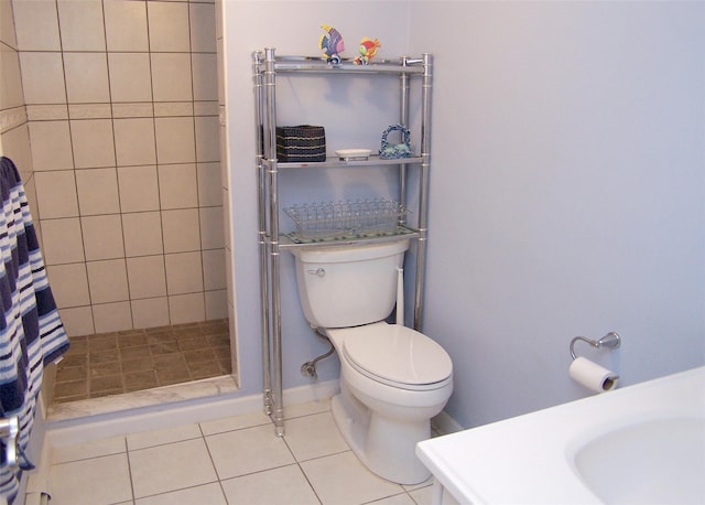 full bathroom featuring tile patterned floors, toilet, a stall shower, and a sink