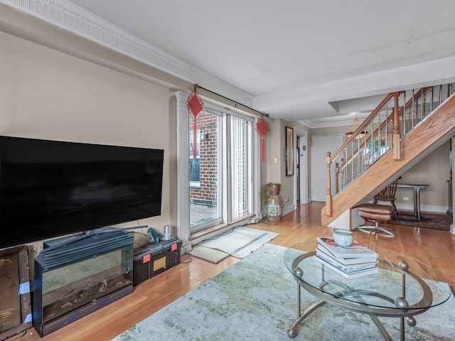 living room featuring crown molding, stairway, wood finished floors, and baseboards