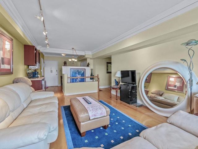 living room featuring an inviting chandelier, crown molding, and light wood-style floors