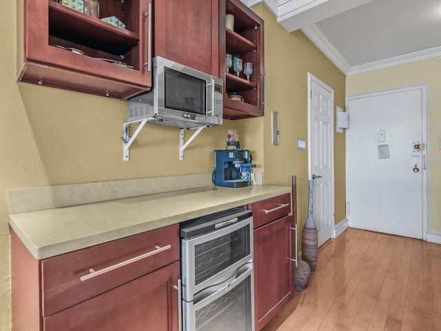 kitchen with open shelves, stainless steel microwave, wine cooler, reddish brown cabinets, and crown molding