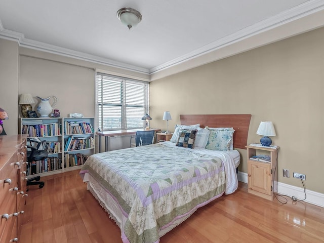 bedroom with crown molding, wood finished floors, and baseboards