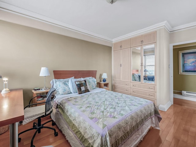 bedroom featuring light wood-type flooring, baseboards, a baseboard heating unit, and crown molding