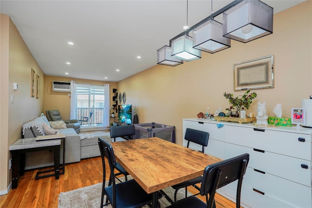 dining area with recessed lighting, light wood finished floors, and a wall unit AC