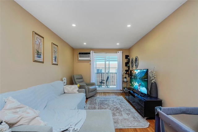 living area with recessed lighting, an AC wall unit, and light wood-type flooring