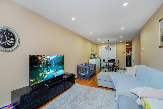 living room with baseboard heating, recessed lighting, and wood finished floors