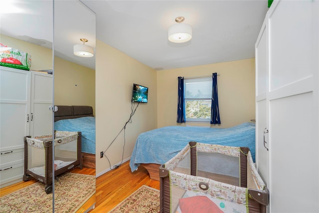 bedroom featuring baseboards and wood finished floors