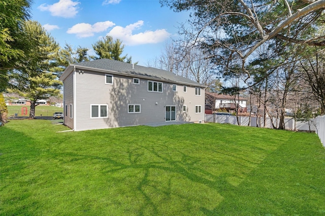 back of property with a yard and fence