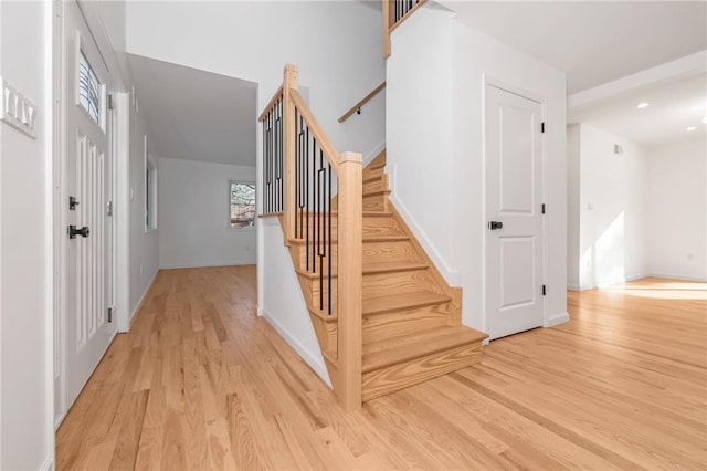 stairway with wood finished floors and baseboards