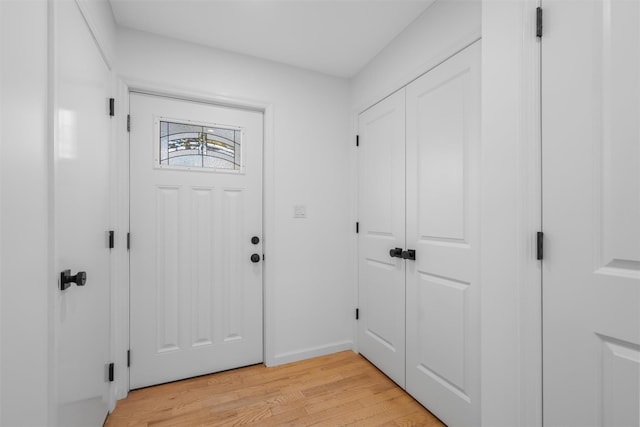 entryway with baseboards and light wood finished floors