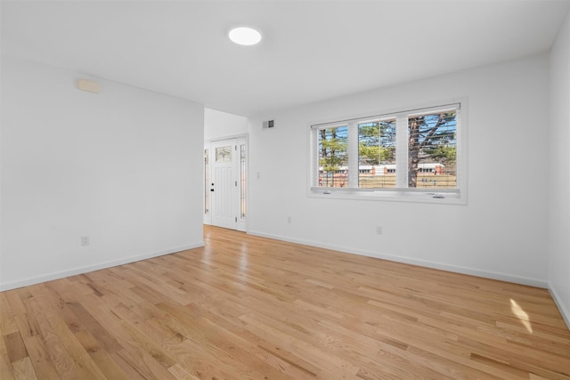 spare room featuring visible vents, baseboards, and light wood-type flooring