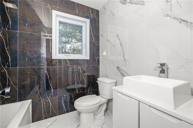 full bath with tile walls, toilet, shower / bathing tub combination, marble finish floor, and vanity