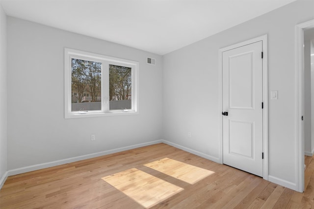 spare room with visible vents, baseboards, and light wood finished floors