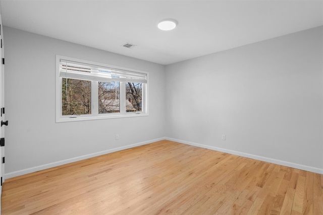 empty room with visible vents, baseboards, and light wood-style floors