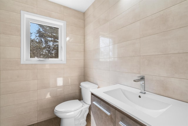 half bath featuring toilet, tile walls, and vanity