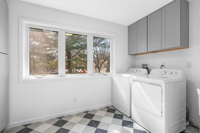 laundry room featuring baseboards, cabinet space, light floors, and washer and clothes dryer