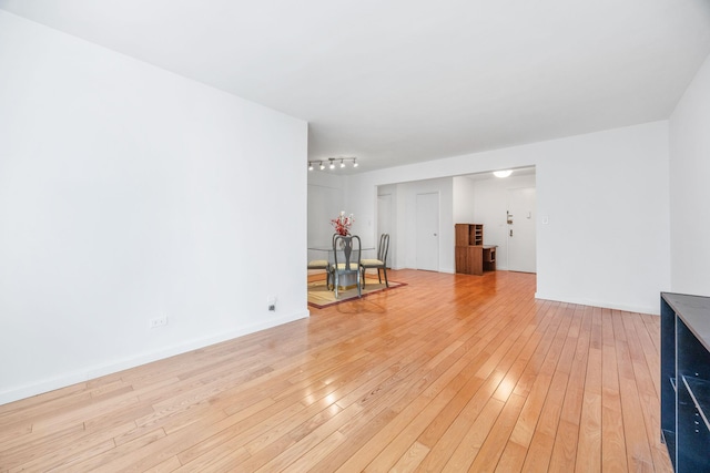 unfurnished living room with light wood-style flooring and baseboards