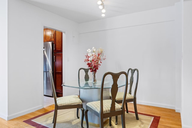 dining area featuring light wood-type flooring and baseboards