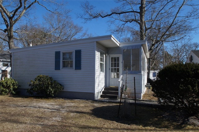 view of front of home with entry steps and a sunroom