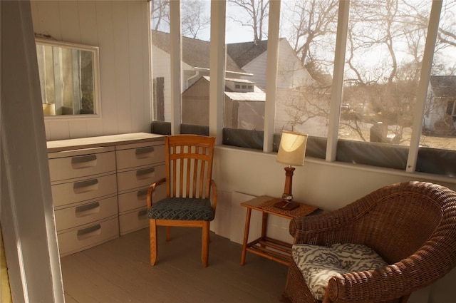 sitting room with wooden walls and wood finished floors