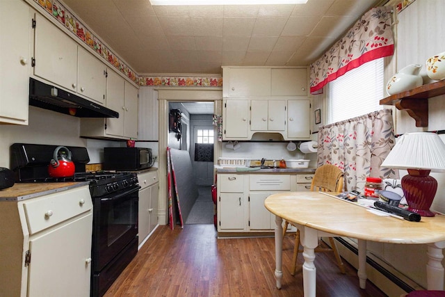 kitchen featuring light wood-type flooring, black appliances, under cabinet range hood, light countertops, and baseboard heating