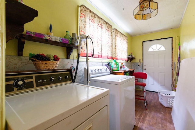 clothes washing area featuring washer and dryer, laundry area, and wood finished floors