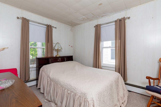 bedroom featuring a baseboard heating unit and light colored carpet