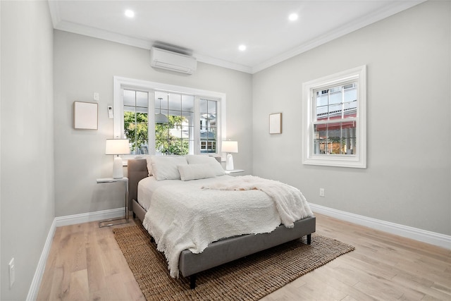 bedroom featuring light wood finished floors, baseboards, and a wall unit AC