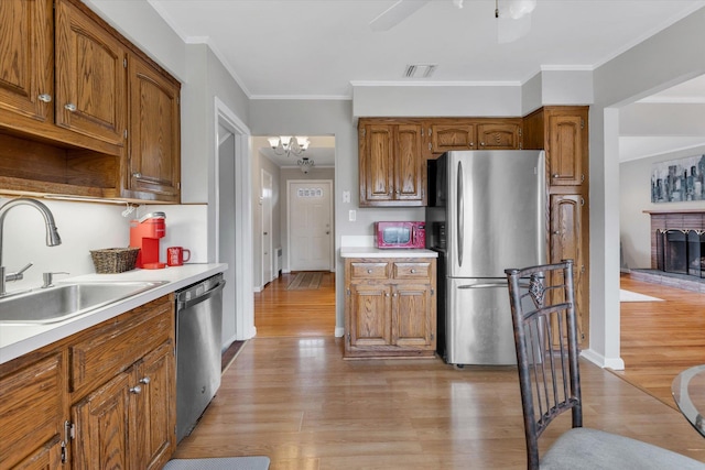 kitchen with a sink, light wood-style floors, visible vents, and stainless steel appliances