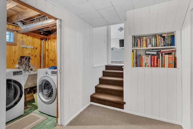 clothes washing area featuring laundry area, carpet, and washer and clothes dryer