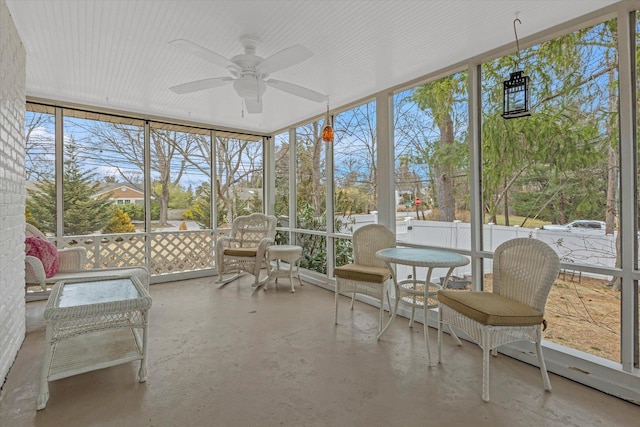 unfurnished sunroom featuring a ceiling fan