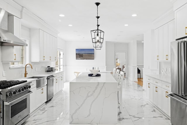 kitchen with a kitchen island, a sink, stainless steel appliances, wall chimney range hood, and marble finish floor