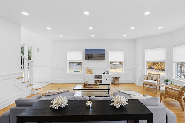 living room with recessed lighting, a wainscoted wall, stairs, and light wood finished floors