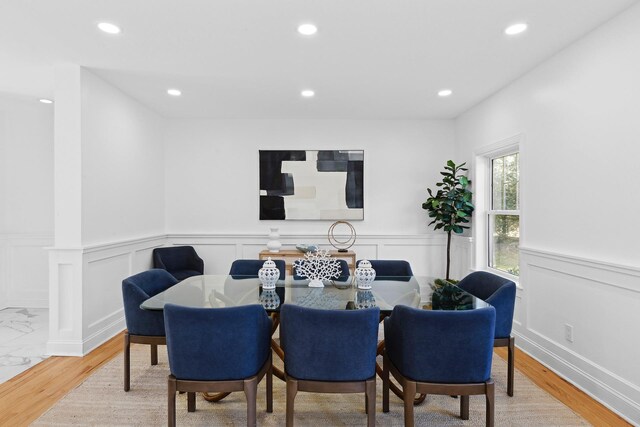 dining space with a wainscoted wall, recessed lighting, and wood finished floors