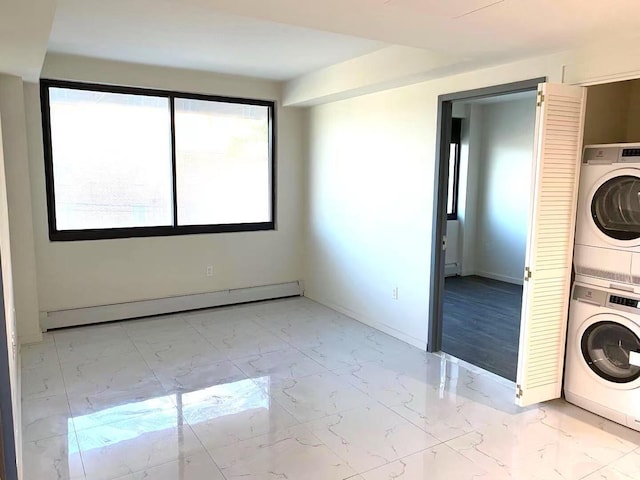 clothes washing area with baseboards, stacked washer and dryer, laundry area, marble finish floor, and a baseboard radiator