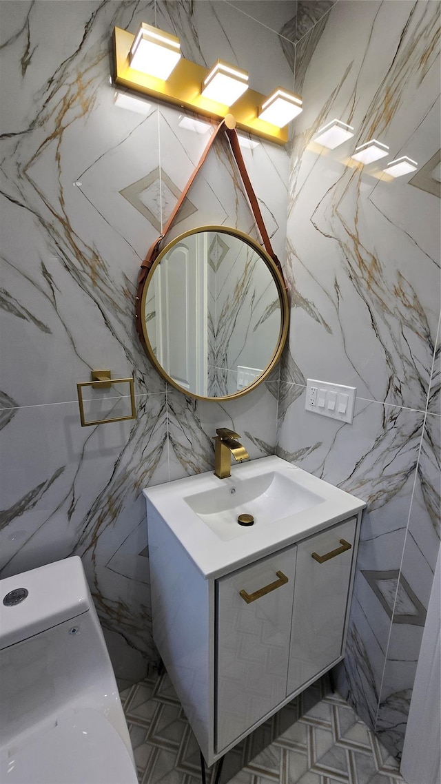 half bath featuring stone wall and vanity