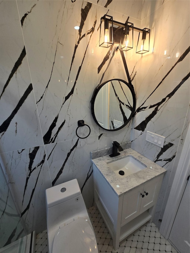 half bathroom with vanity, stone wall, and toilet