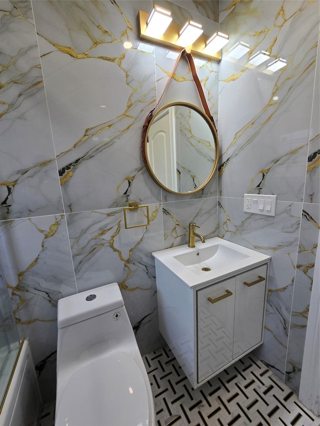 bathroom featuring vanity, stone wall, and toilet