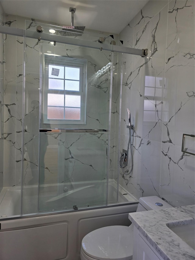 full bath featuring tile walls, combined bath / shower with glass door, toilet, and vanity