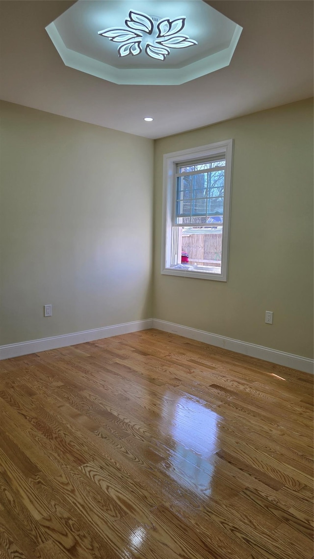 unfurnished room with baseboards and wood finished floors