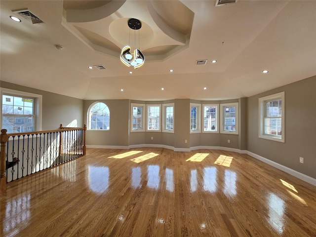 spare room with visible vents, baseboards, recessed lighting, wood finished floors, and a raised ceiling