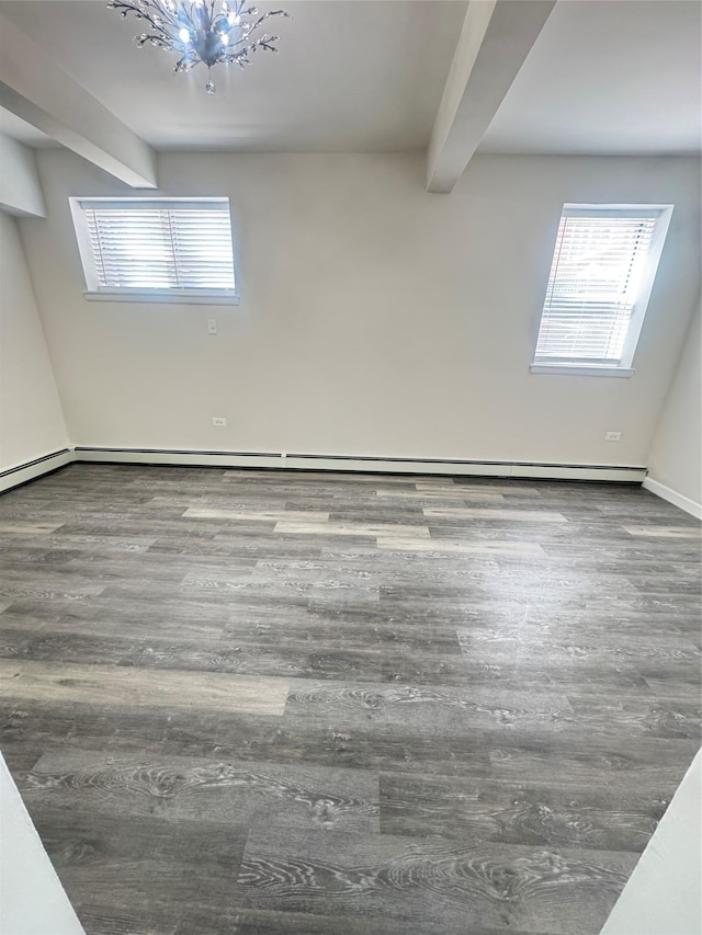 empty room with beamed ceiling, a baseboard heating unit, and wood finished floors