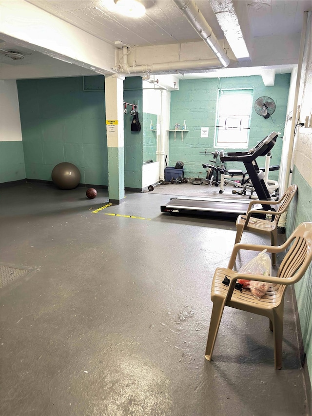 exercise room featuring concrete block wall