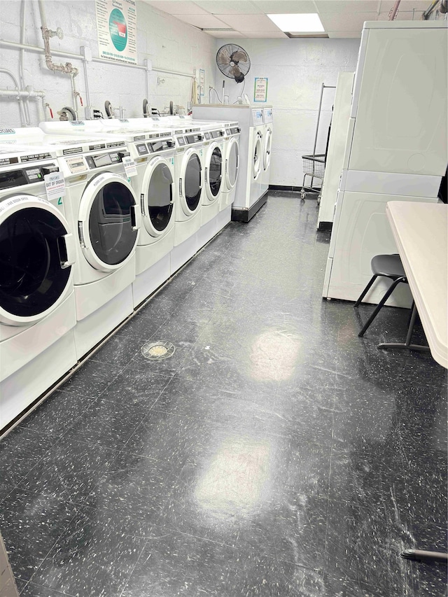 shared laundry area featuring washer and dryer and concrete block wall