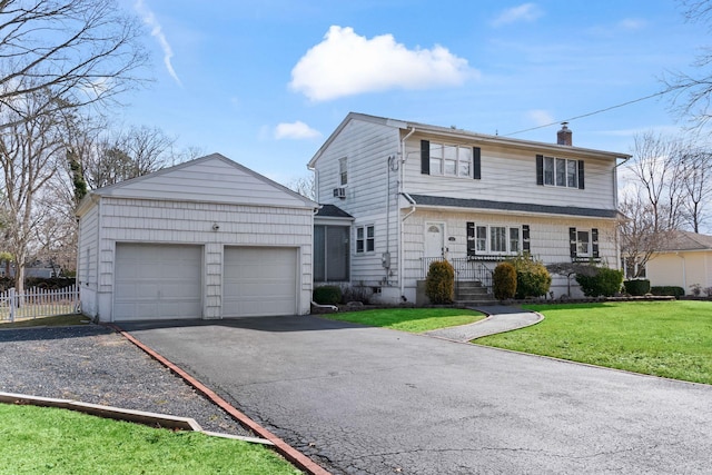 view of front of home with an outbuilding, driveway, fence, a front yard, and a chimney