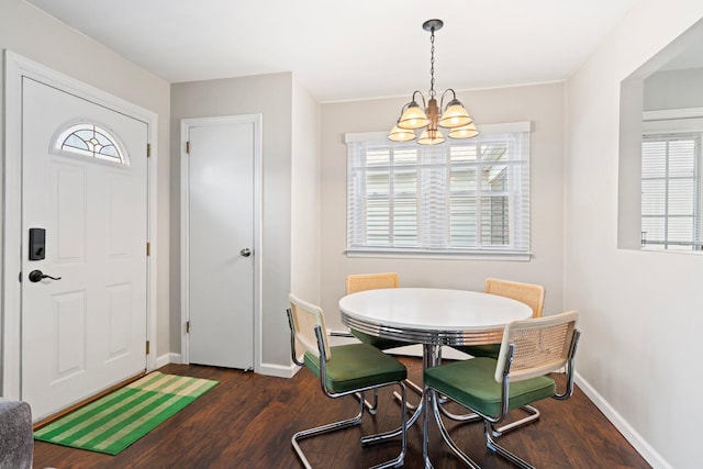 dining space featuring baseboards, a notable chandelier, and wood finished floors